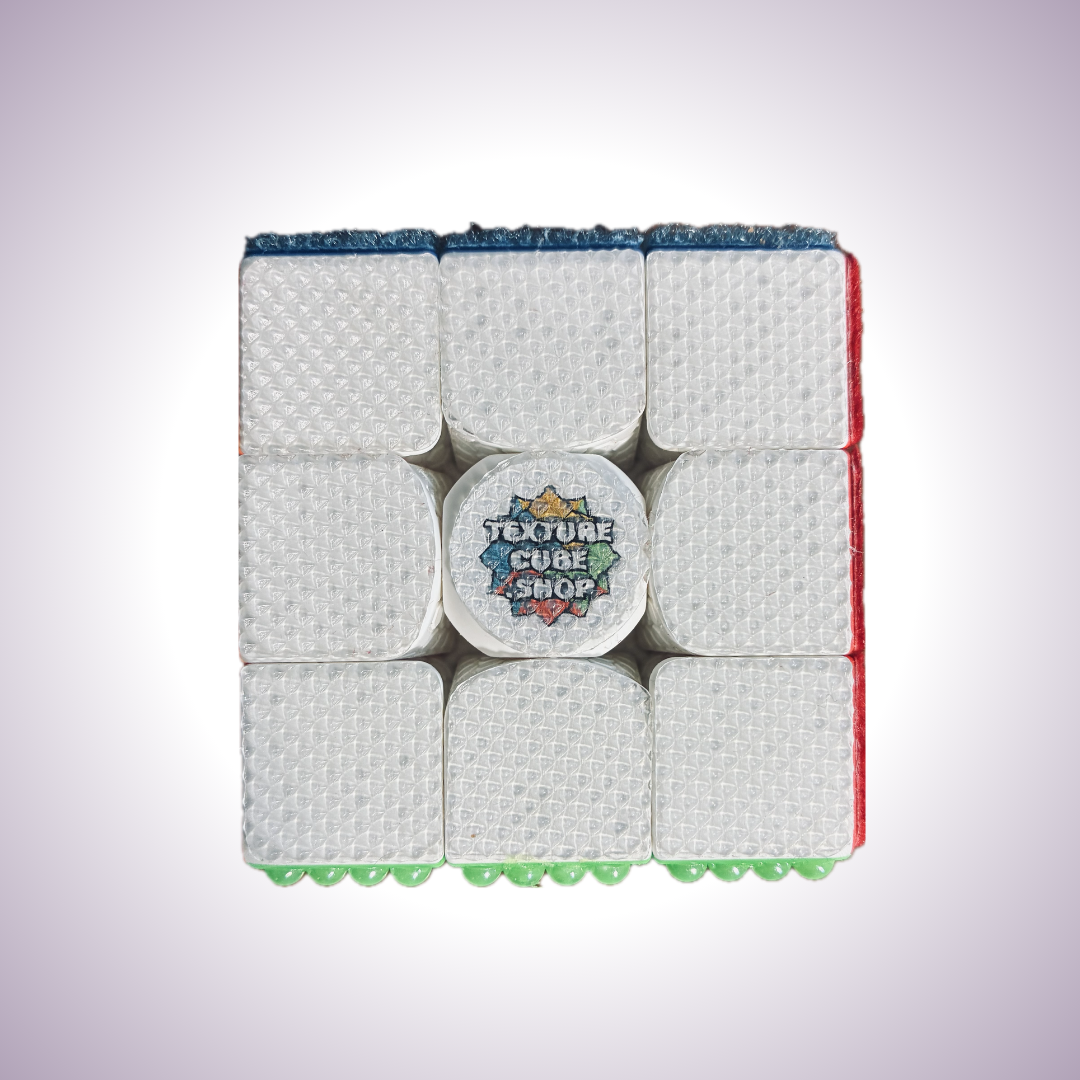 Close up of white side of a Rubik's Cube. Textured with a fine grainy diamond pattern.