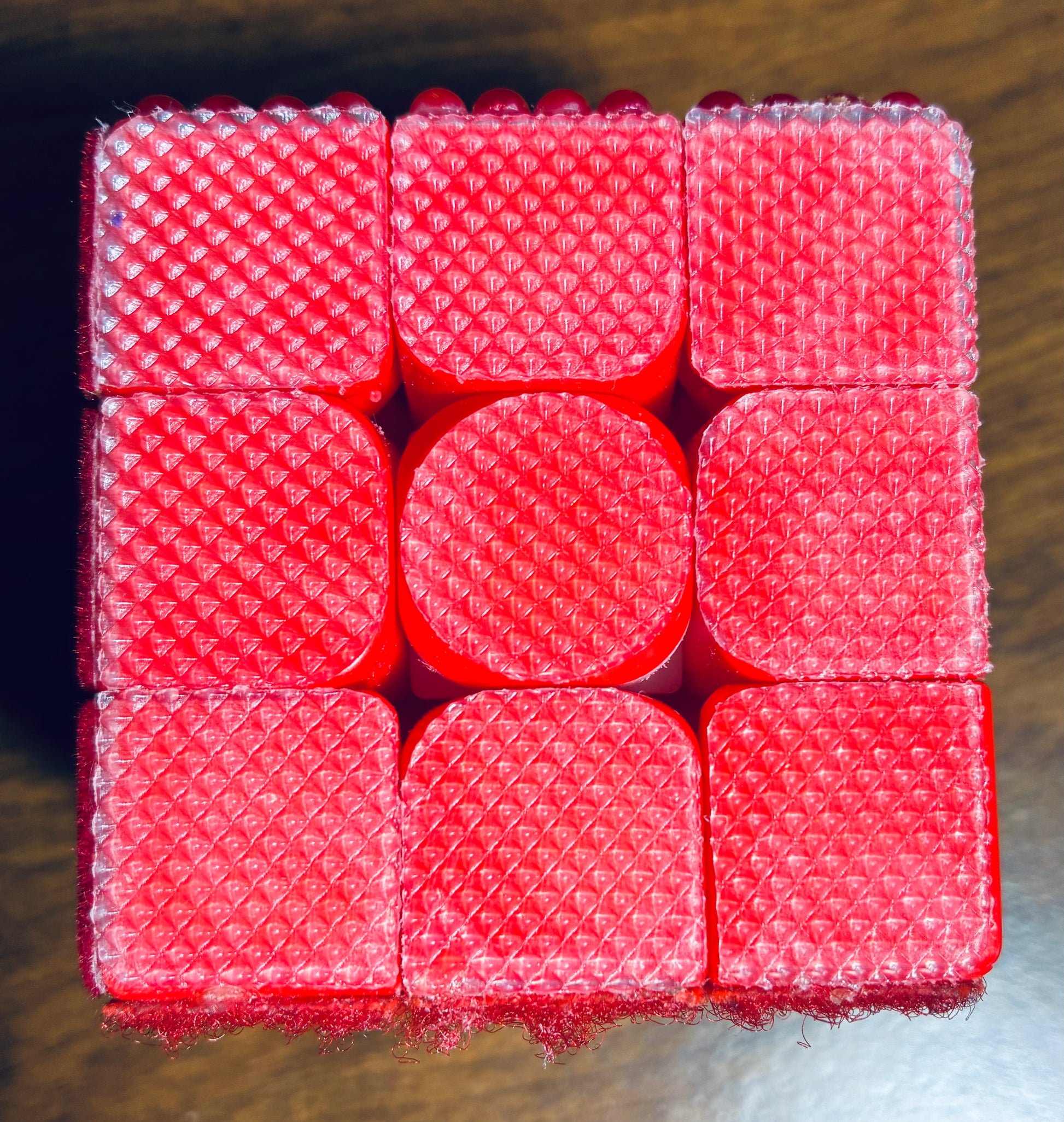Close up off red rough grippy rubberized texture, has a fine diamond pattern